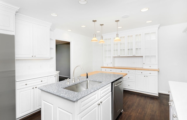kitchen with white cabinets, appliances with stainless steel finishes, a sink, and glass insert cabinets