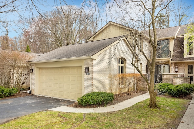 view of front of house featuring brick siding, an attached garage, roof with shingles, and aphalt driveway