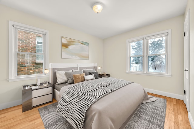 bedroom featuring light wood finished floors and baseboards