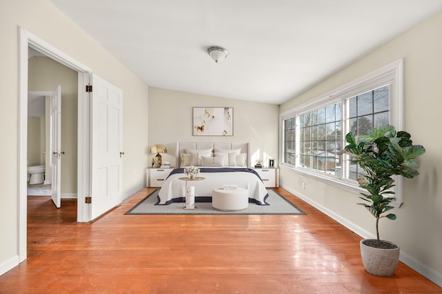 bedroom with wood finished floors and baseboards