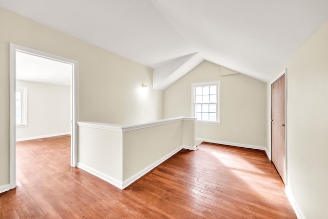 bonus room featuring lofted ceiling, wood-type flooring, and baseboards