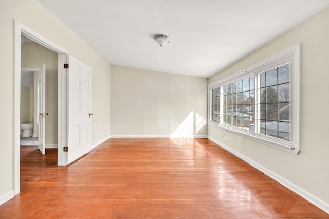 empty room with baseboards and wood finished floors