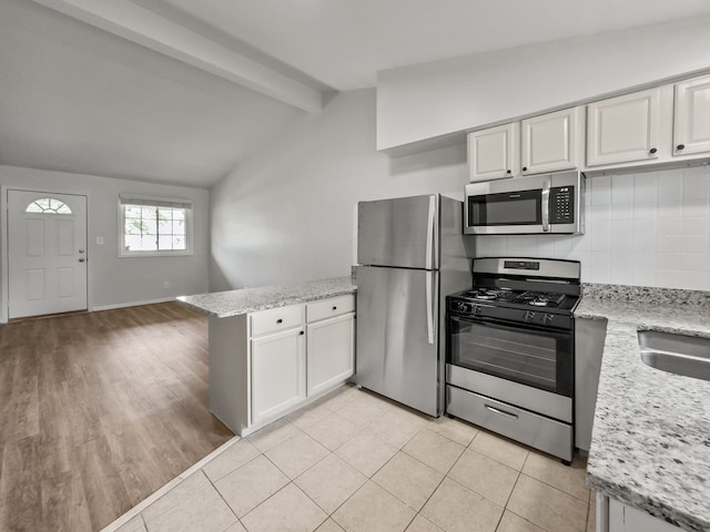 kitchen with white cabinets, tasteful backsplash, and stainless steel appliances