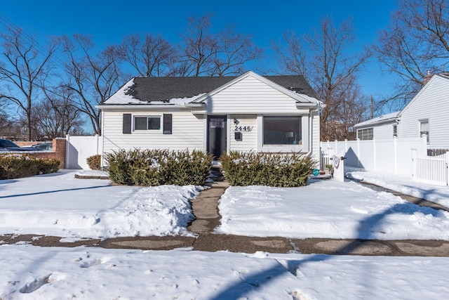 view of front facade with a detached garage and fence