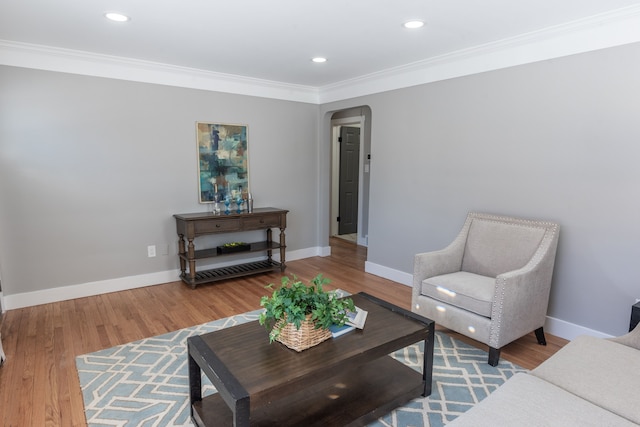 living room featuring arched walkways, baseboards, and wood finished floors