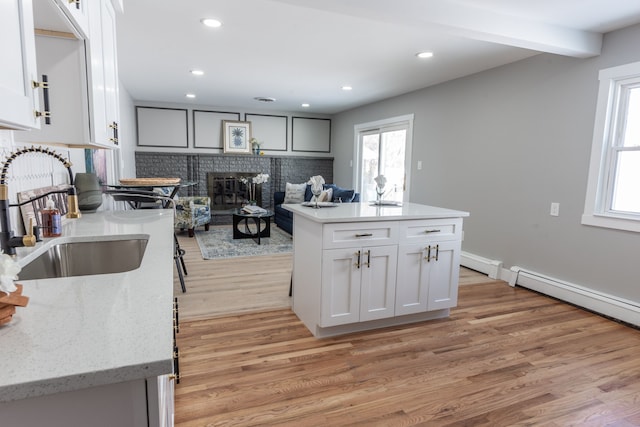 kitchen with a wealth of natural light, white cabinets, a sink, and a center island