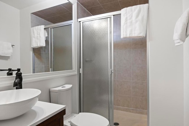 full bathroom featuring toilet, a stall shower, and vanity