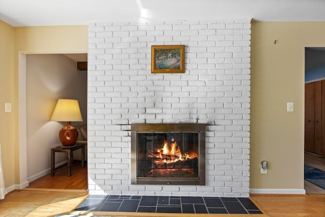 interior details featuring a fireplace, baseboards, and wood finished floors