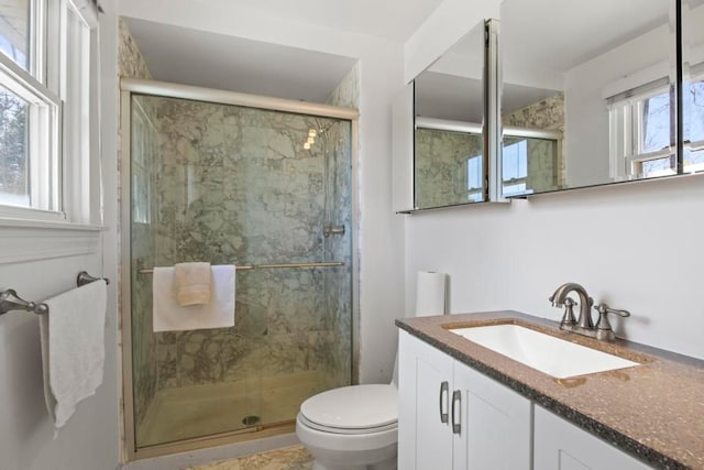 full bathroom featuring toilet, vanity, and a marble finish shower