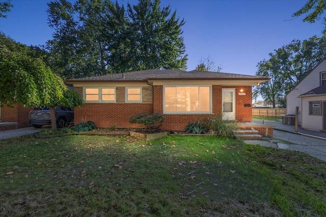 view of front of house featuring a front lawn and brick siding