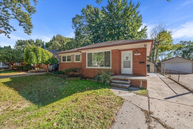 bungalow-style house with an outbuilding, brick siding, a front lawn, and a garage