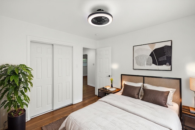 bedroom with a closet, dark wood-style flooring, and baseboards