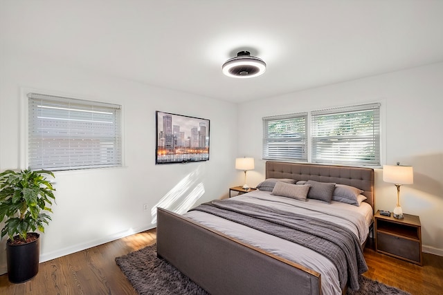 bedroom with dark wood-style floors and baseboards