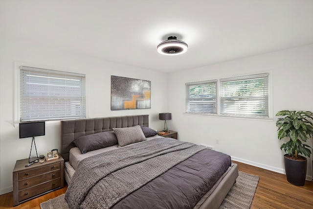 bedroom featuring dark wood-style flooring and baseboards