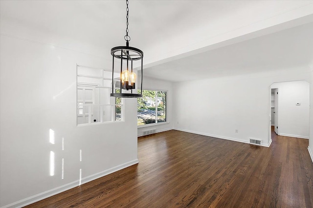 unfurnished dining area featuring baseboards, arched walkways, visible vents, dark wood-type flooring, and a chandelier