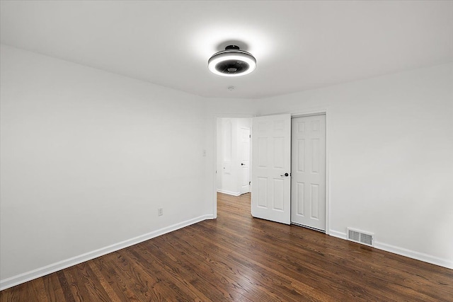 unfurnished bedroom featuring baseboards, visible vents, and dark wood finished floors