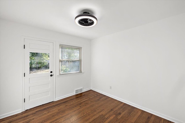 interior space with dark wood-type flooring, visible vents, and baseboards