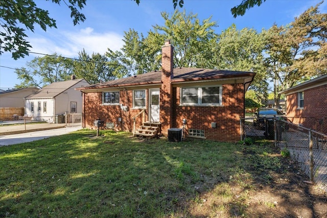 view of front of home with entry steps, brick siding, a chimney, and a front lawn