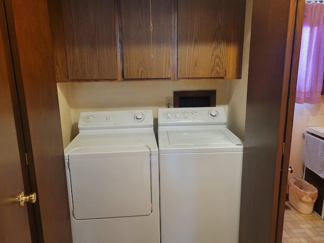 clothes washing area with independent washer and dryer and cabinet space