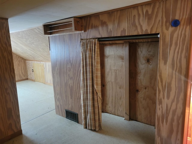 bonus room featuring lofted ceiling, wooden walls, and visible vents