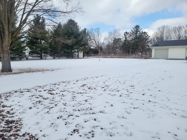 snowy yard featuring a garage