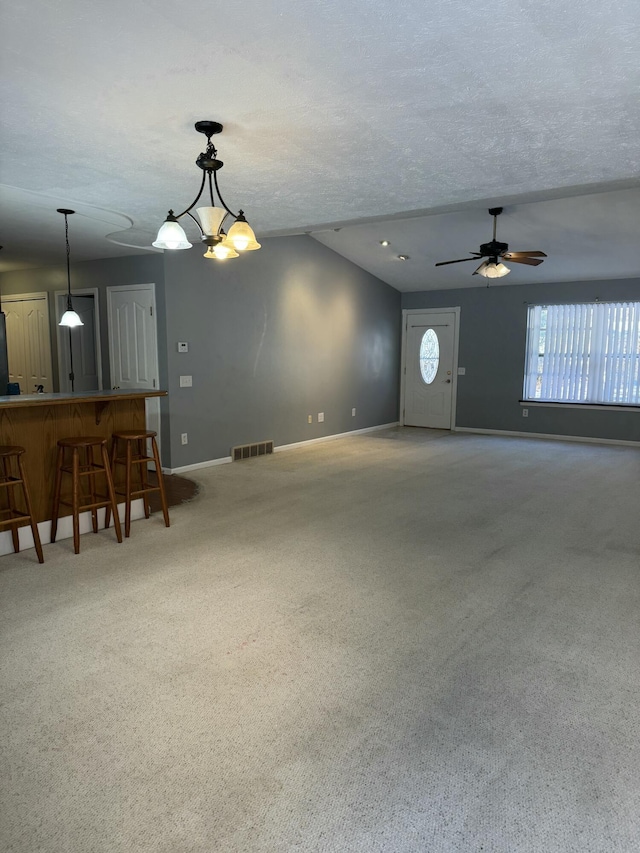 unfurnished living room featuring a textured ceiling, carpet flooring, a ceiling fan, and baseboards