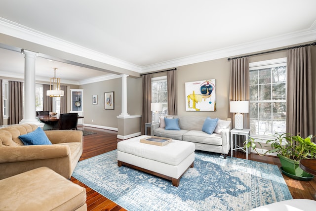 living room featuring ornate columns, plenty of natural light, and wood finished floors