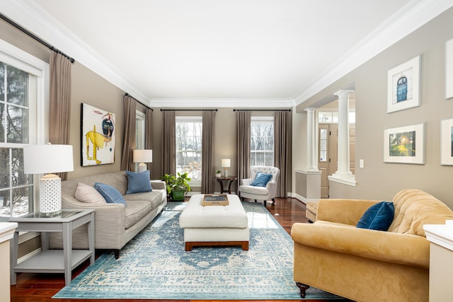 living room featuring dark wood-style flooring, decorative columns, and crown molding