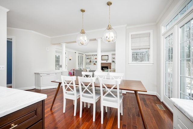 dining room featuring crown molding, dark wood finished floors, visible vents, and decorative columns