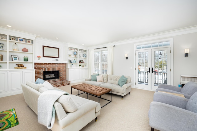 living room featuring a healthy amount of sunlight, a fireplace, ornamental molding, and french doors