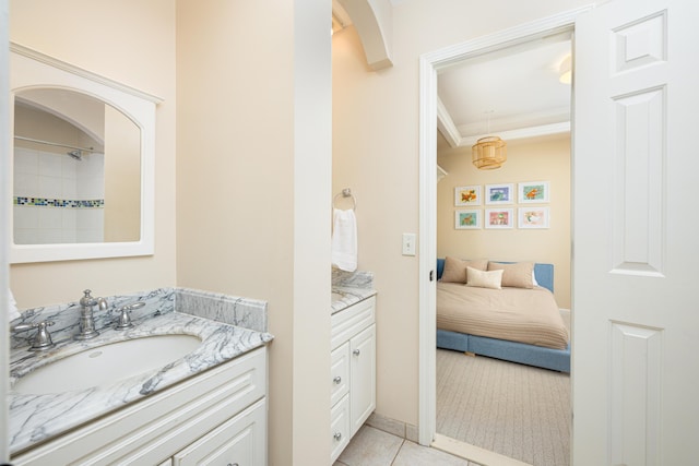 ensuite bathroom with connected bathroom, vanity, and tile patterned floors