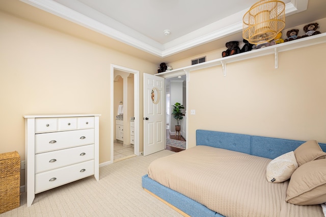 bedroom featuring visible vents, ensuite bathroom, crown molding, and light colored carpet