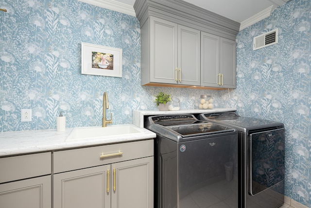 laundry room featuring wallpapered walls, cabinet space, visible vents, independent washer and dryer, and a sink