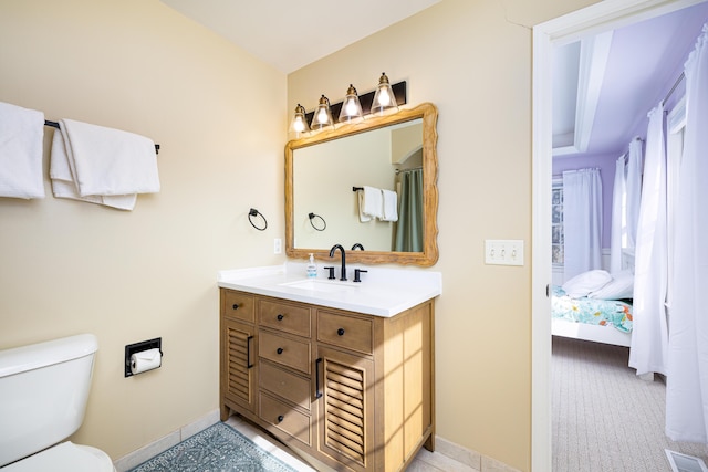 bathroom featuring connected bathroom, toilet, vanity, baseboards, and visible vents