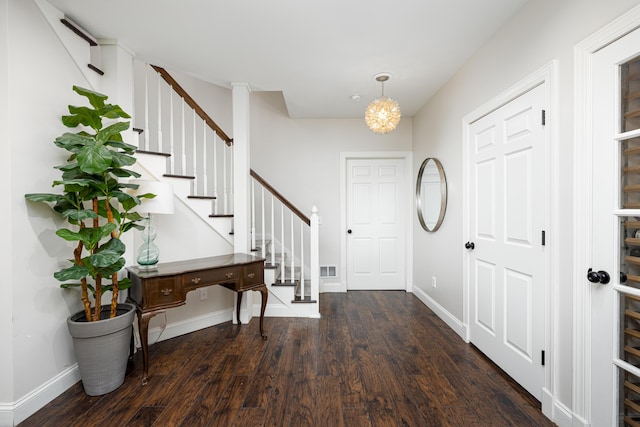 foyer entrance with stairs, baseboards, and dark wood-type flooring