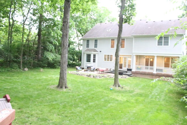 back of house with a lawn and a patio area