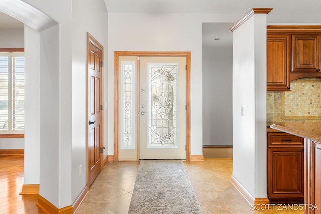 entrance foyer with light tile patterned floors and baseboards