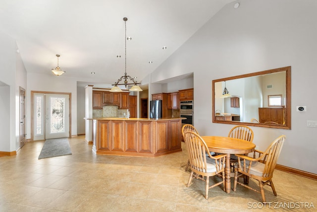 dining area featuring light tile patterned floors, baseboards, and high vaulted ceiling