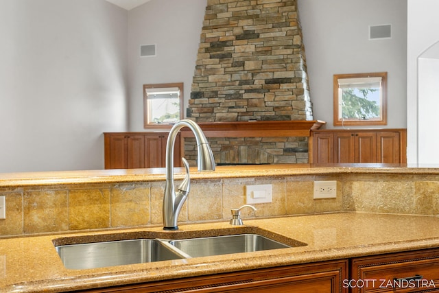 kitchen featuring brown cabinetry, light countertops, visible vents, and a sink