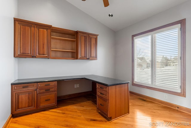 unfurnished office featuring lofted ceiling, light wood-style floors, baseboards, and built in study area