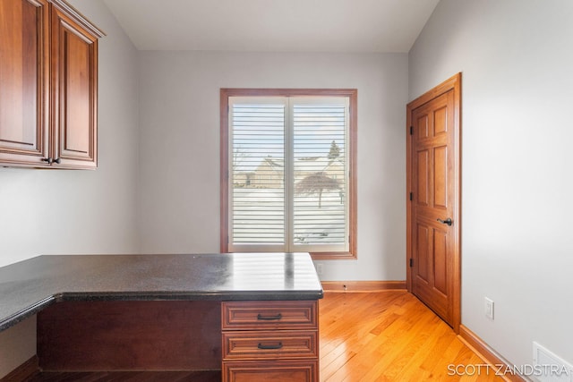 unfurnished office featuring light wood-style flooring and baseboards