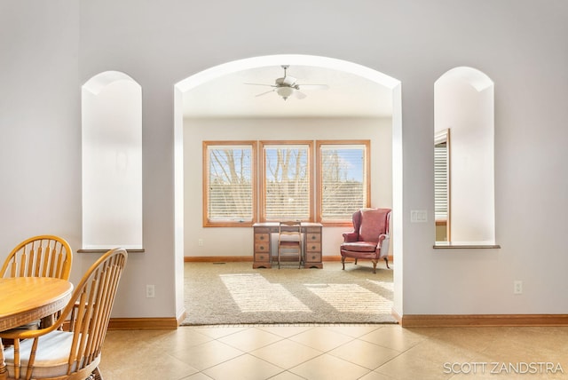 interior space featuring light tile patterned floors, a ceiling fan, and baseboards