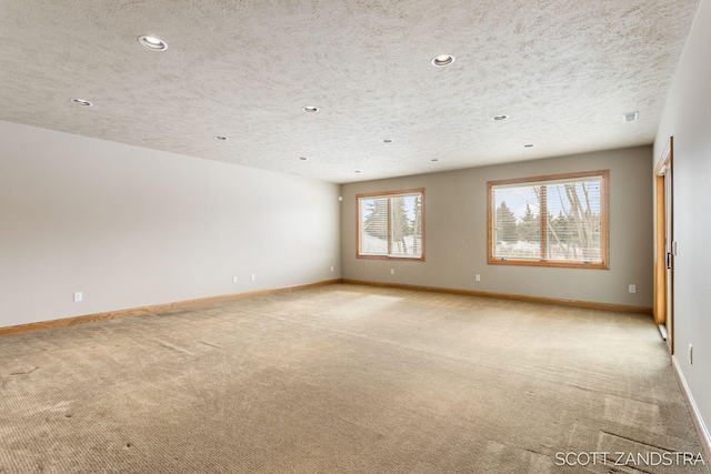 unfurnished room featuring visible vents, baseboards, light colored carpet, a textured ceiling, and recessed lighting