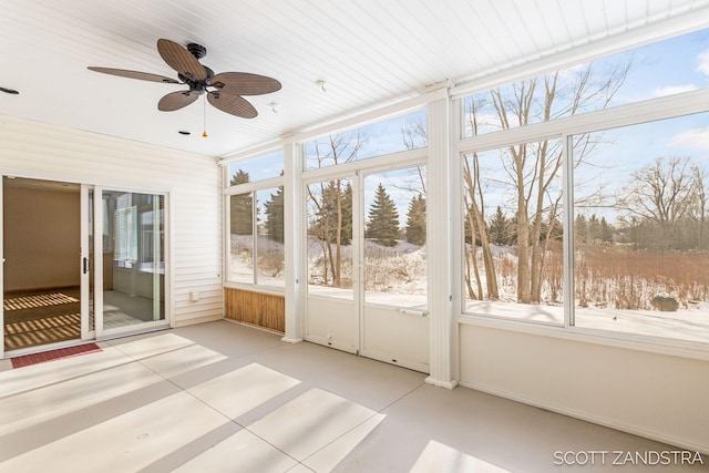 unfurnished sunroom featuring ceiling fan