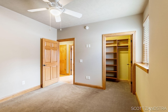 unfurnished bedroom featuring light carpet, a spacious closet, a closet, and baseboards