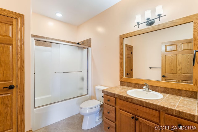 full bathroom with shower / bath combination with glass door, tile patterned flooring, vanity, and toilet