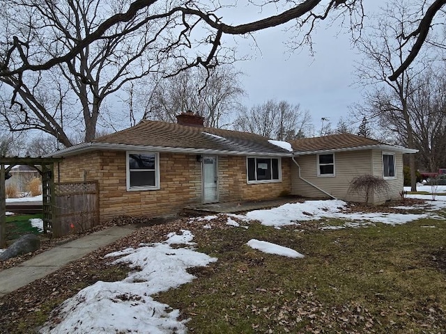 single story home featuring stone siding and a chimney