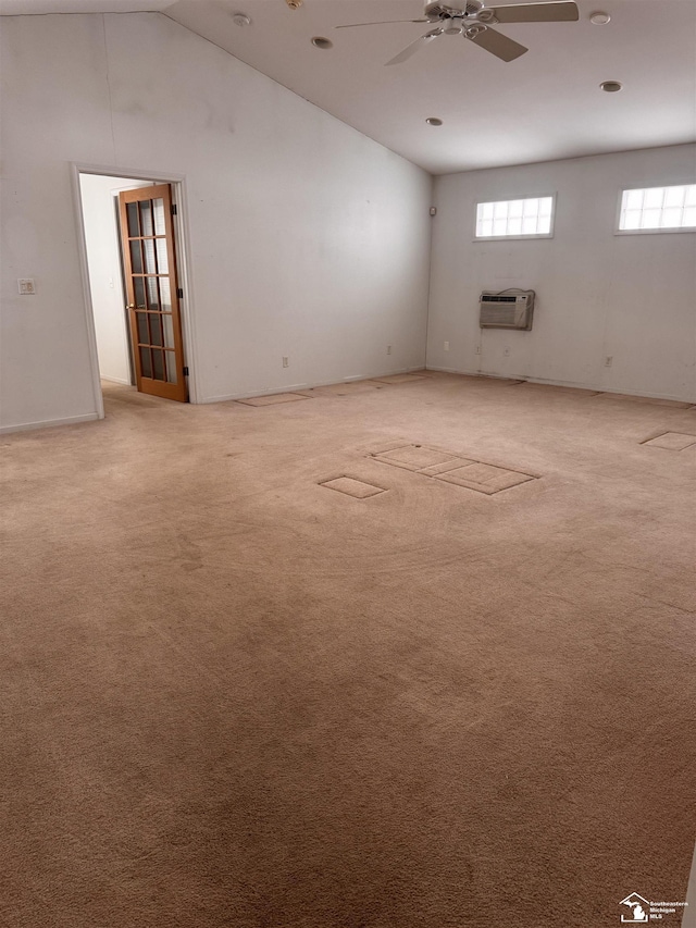 empty room with high vaulted ceiling, carpet flooring, a wall unit AC, and ceiling fan