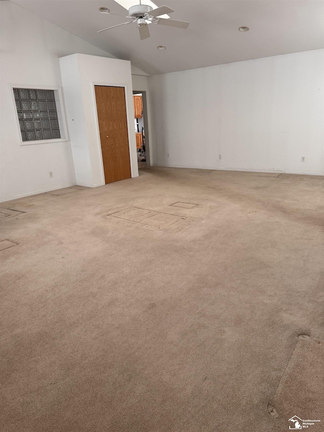 empty room with light carpet, ceiling fan, and vaulted ceiling