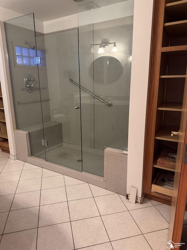 bathroom featuring a stall shower, tile patterned flooring, and a closet